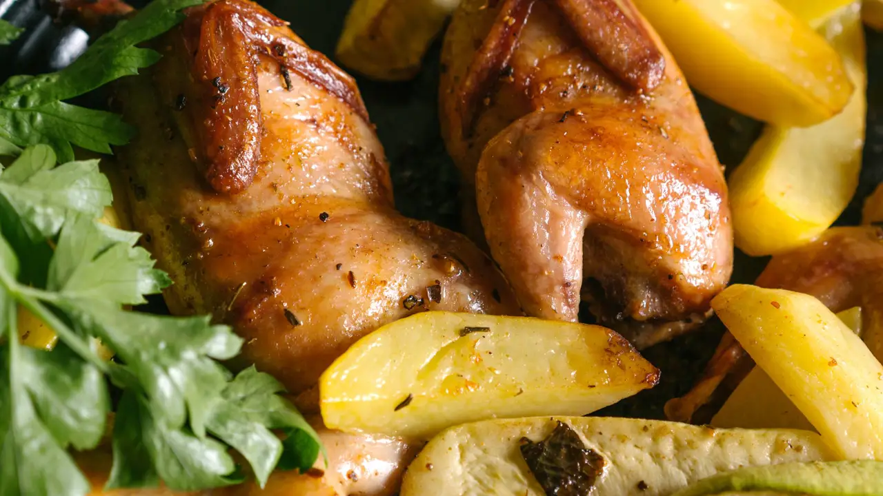 Roasted chicken with potatoes on a black tray