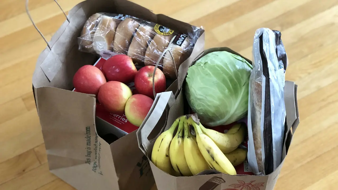 שקיות נייר עם מצרכים: תפוחים, כרוב ובננות